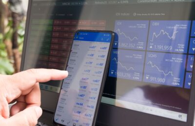 Smartphone et ordinateur affichant des graphiques financiers pour illustrer Trade Republic et l’investissement mobile