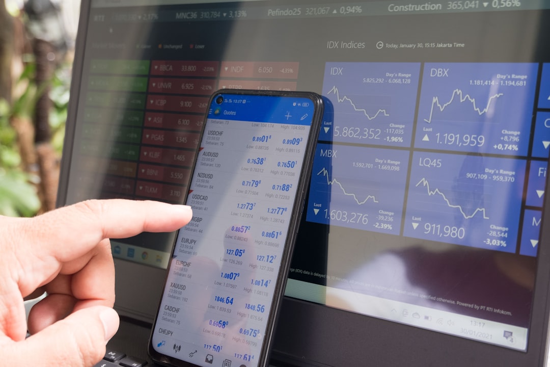 Smartphone et ordinateur affichant des graphiques financiers pour illustrer Trade Republic et l’investissement mobile